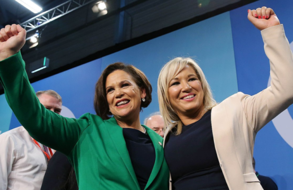 Mary Lou McDonald (Left) and Michelle O’Neill (right) at Ard Fheis (2018). Photo credit: Sinn Fein/Wikicommons