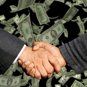 handshake over dollar bills