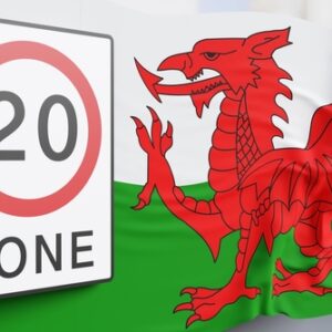Road sign of 20mph zone and Welsh national flag in front of a street view. 3D illustration of the concept that Wales has lowered the speed limit on one-way roads in towns and cities