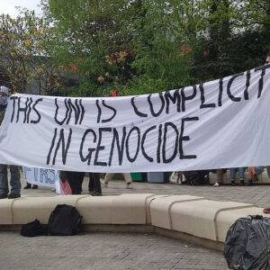 Students protest at Sheffield University, banner says "This uni is complicit in genocide"