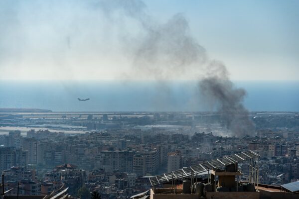 A plane taking off from Beirut International Airport as smoke rises from airstrike on Beirut southern suburbs, amid ongoing war between Hezbollah and Israel in October 2024