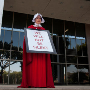 Los Angeles, California - June 30, 2018: A woman dressed as a handmaid from the novel and television series A Handmaid's Tale to protest the Trump Administration at the Families Together March Rally.