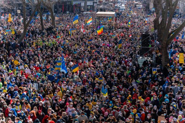 Large crowd photographed from air so individuals are bit clear but a few flags are visible