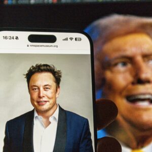 image of Elon Musk on mobile phone with photo of Donald Trump in bacground