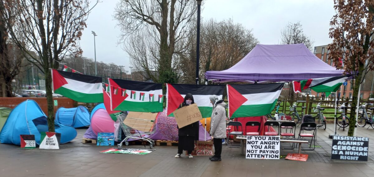 Tents Palestinian glags and placrds: If you are not angry you are not paying attention and Resisting against genocide is a human right