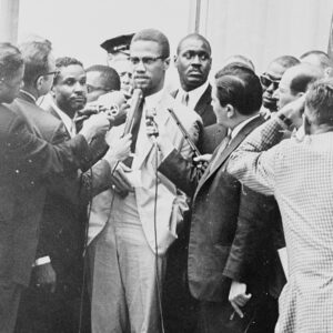 Malcolm X being interviewed by reporters, including WNBC's Gabe Pressman and a cameraman with an Auricon CineVoice 'Chop Top'