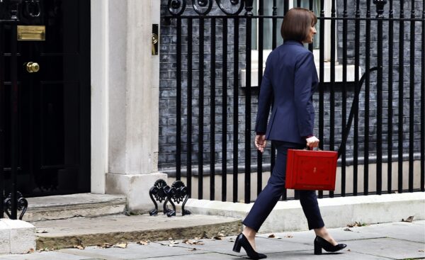 Rachel Reeves with her back to camea walking away from No 11 with red briefcase in hand