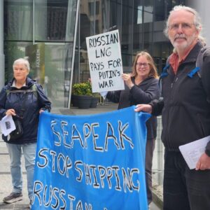 Blue banner with tellow writing reading Seapeak stop Russian LNG and placard reading Russian LNG fuuds Putin's war