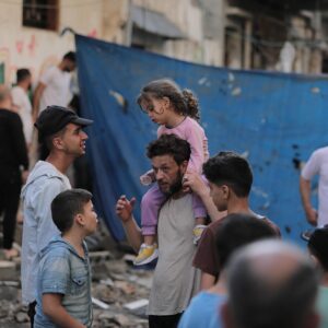 A group of people gathered in rubble in Gaza.
