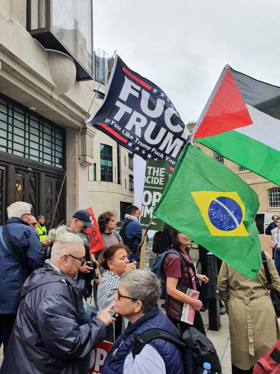 Assembling for Stop Trump demo 17 September. Flags include a Palestinian and Brazilian flag tofgether and a flag syaing Fuck Trump