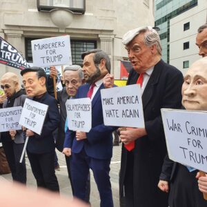 Protestors with papier mache heads representing key world leaders with hand made placards. Trumps is Make America hate again again. Others include War criminals for Trump and Murders for Trump