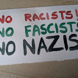 Banner with text: "No Racists! No Fascists! No Nazis!" in Red, Green, and Black respectively.