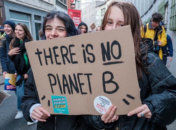 Two people holding cardboard sign: There is no Planet B