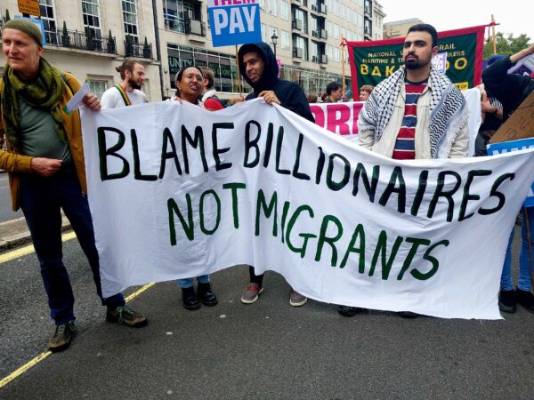 Hanf made banner Blame billionaires not migrants