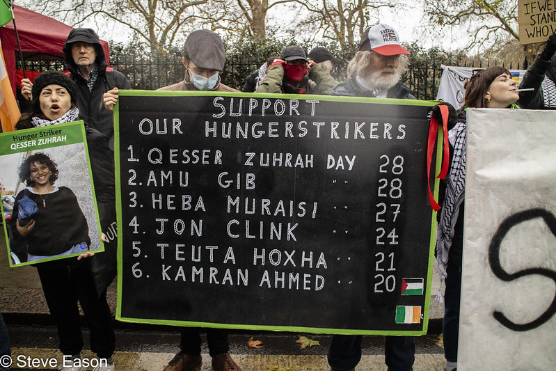 Protestors with placard with names of six hunger strikers on 29 Nov demonstration. Photo: Steve Eason