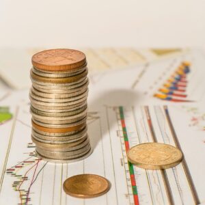 Stacks of money on top paper with market trend graphs