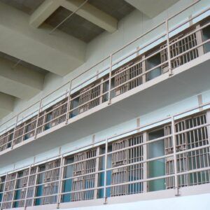 Depiction of prison cells on balconies, white walls.