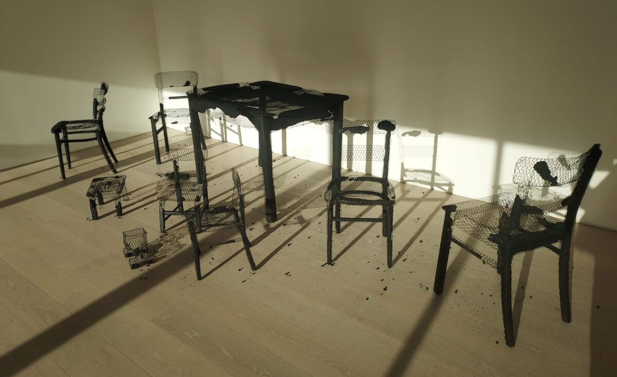 Sculpture of burnt out/bombed tables and chairs by Mona Hatoum