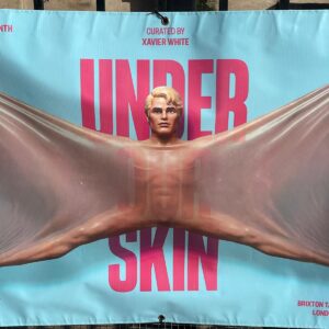 A ken doll with skin stretched over a blue background with Under Skin visible in pink.