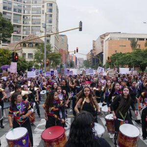 Image of a women's protest against the far right with a group holding drums.