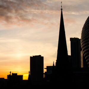 An evening skyline of Birmingham with a mall and church spire.