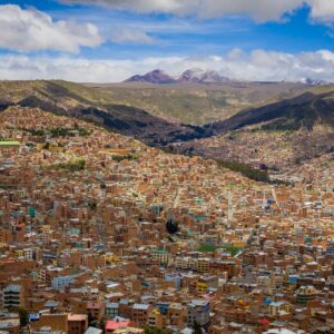 Photograph looking over the Bolivian city of La Paz surrounded by hills and blue skies with clouding.