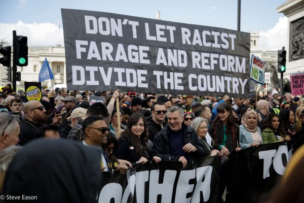 Large black banner with white lettering: Dont ler racisr Daeage and Ewfoen divide the country. Photo: Steve Eason