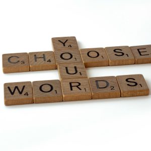Picture of wooden scrabble tiles with intersecting letters reading'chhose your words'