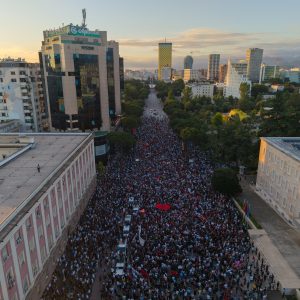 Tirana, Albania - June 4, 2026: Editorial drone photograph showing protesters gathered between major government buildings in Tirana, Albania, with banners, red flags and police vehicles visible during a demonstration connected to Zvernec, Narta and flamingo protection concerns. Photo: Shutterstock